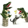 Dinosaur interactive cat hand puppet with feather teaser engaging a tabby cat